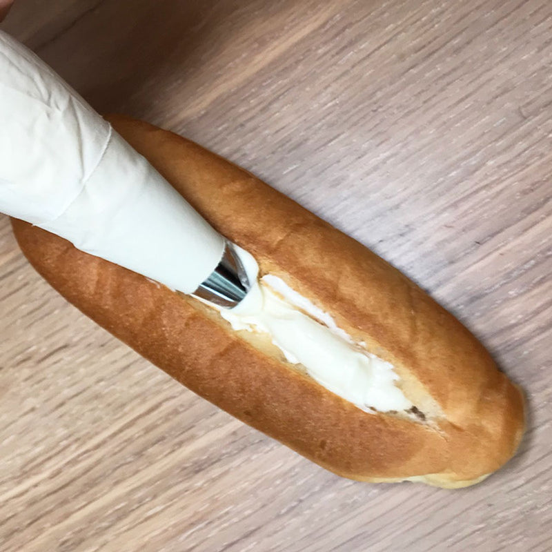 出来上がったミルククリームを絞り袋に入れて、切り込みに沿って流し込みます。